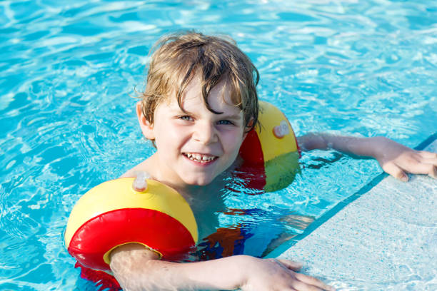 istock Happy little kid boy having fun in an swimming pool 809817848