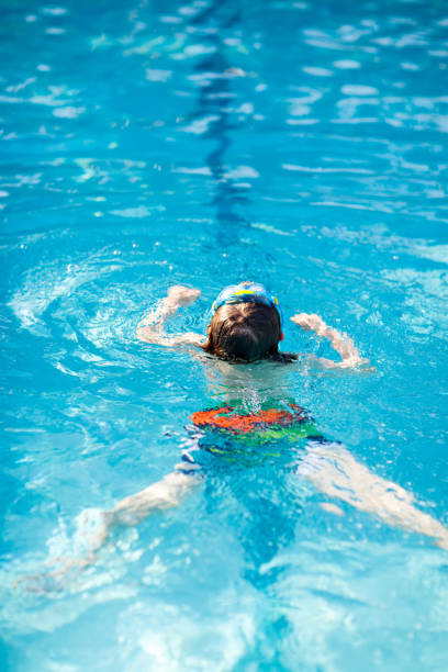 istock Little kid boy making swimming competition in pool 809822338