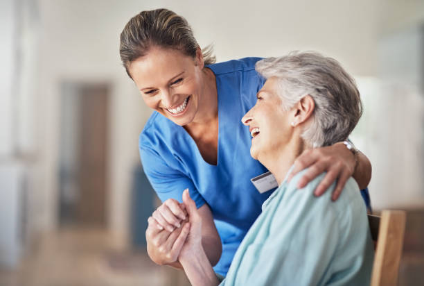 Caring comes naturally to her Shot of a young caregiver caring for her elderly patient in her home senior home stock pictures, royalty-free photos & images