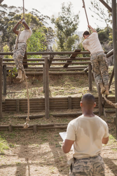 istock Military soldiers climbing rope during obstacle course training 809823084