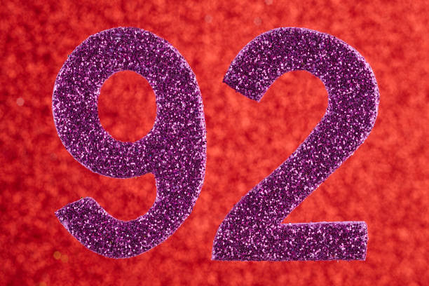 istock Number ninety-two purple color over a red background. Anniversary. 809824278