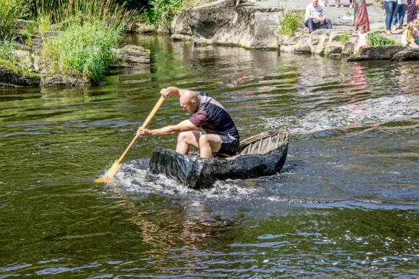 Man paddling Welsh coracle boats Cenarth, UK - July 31, 2016: Man paddling Welsh coracle boats on the River Teifi at Cenarth teifi river stock pictures, royalty-free photos & images