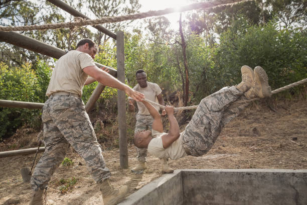 istock Young military soldiers practicing rope climbing during obstacle course 809839208
