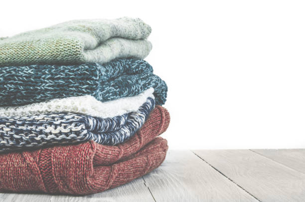 istock Pile of knitted winter clothes on wooden background, sweaters, k 809846310