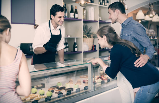 istock Smiling pastryman offering delicious to visitors 809860150