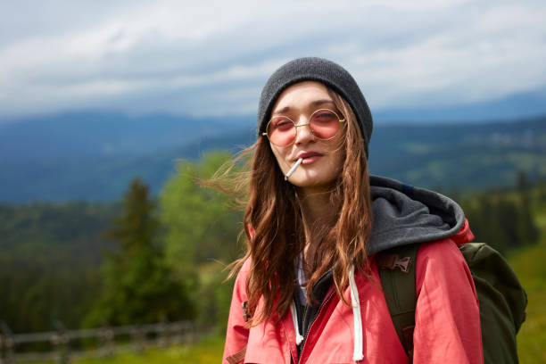 istock Young woman smoking. Mountainous landscape 809863986