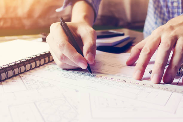 istock Asian man hand drawing on blueprint paper at home office. 809869204