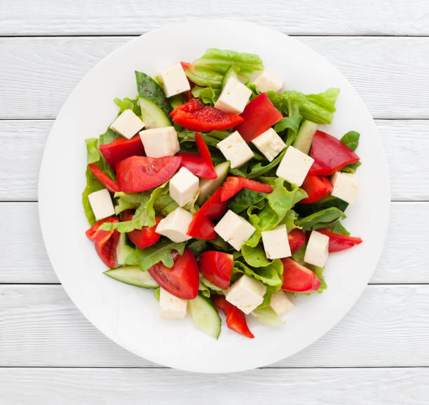 istock Salad with cheese and fresh vegetables top view 809877226