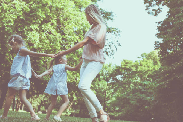istock Mother playing on meadow with her two little daughter. 809897262