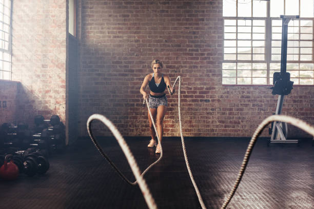 istock Athlete exercising in gym using heavy ropes. 809920324