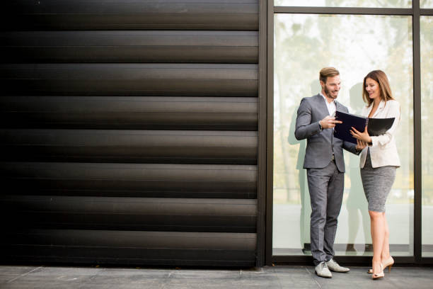 istock Young business people talking and viewing documents outdoor 809920924