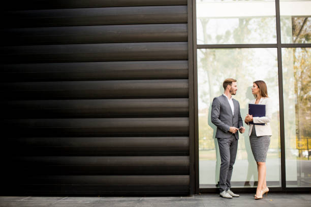 istock Young business people talking and viewing documents outdoor 809920930