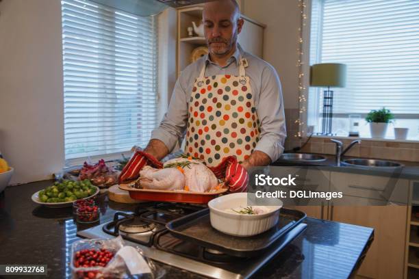 Hombre Haciendo La Cena De Navidad Foto de stock y más banco de imágenes de Cena de asado - Cena de asado, Cocinar, 40-49 años