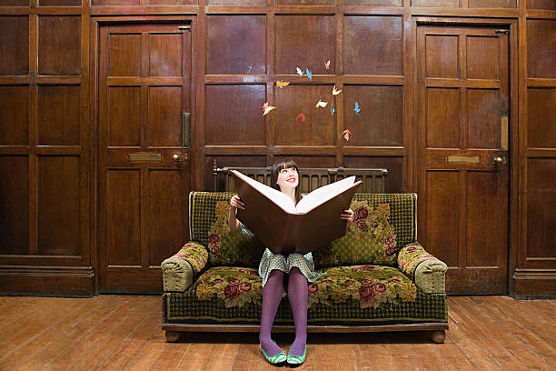 A teenage girl reading a large book  teenagers only photos stock pictures, royalty-free photos & images