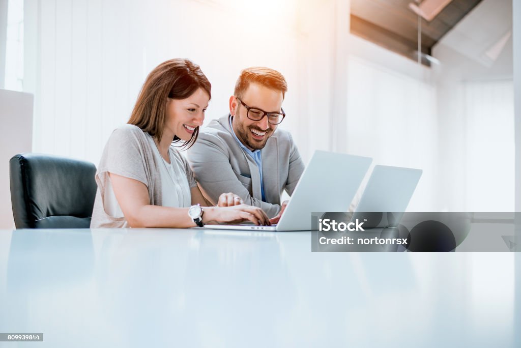 Group of confident business partners working with laptop in office Laptop Stock Photo