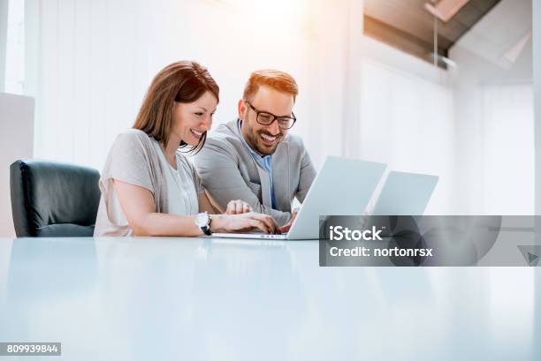 Group Of Confident Business Partners Working With Laptop In Office Stock Photo - Download Image Now