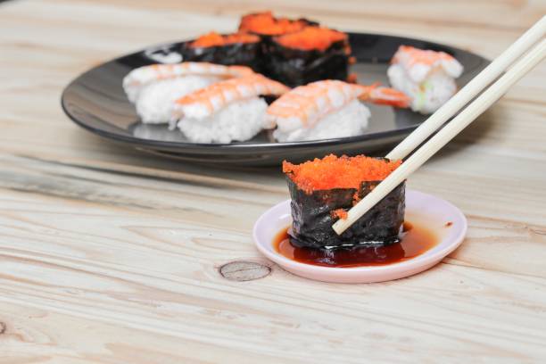 istock hand holding sushi chopsticks on a black plate wooden table  background 809940368