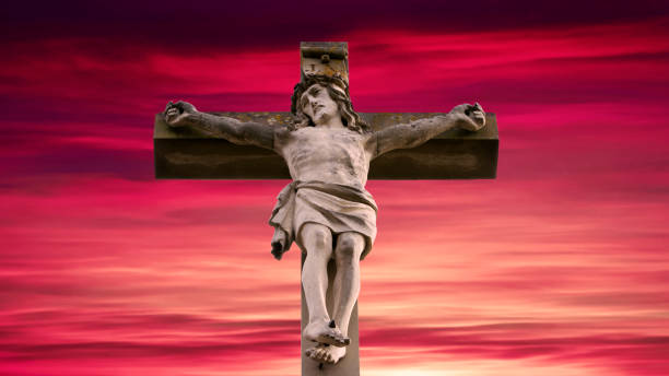 istock stone cross with Jesus and red sky 809940760