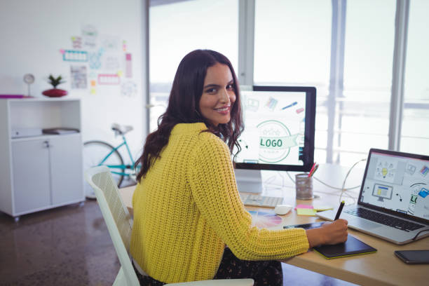 Smiling female graphic designer working in creative office stock photo