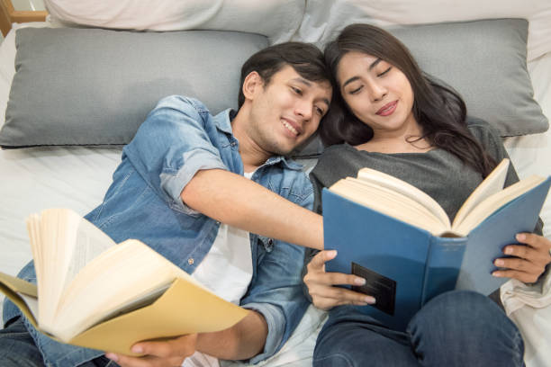istock Young loving couple reading book at home. 809982472