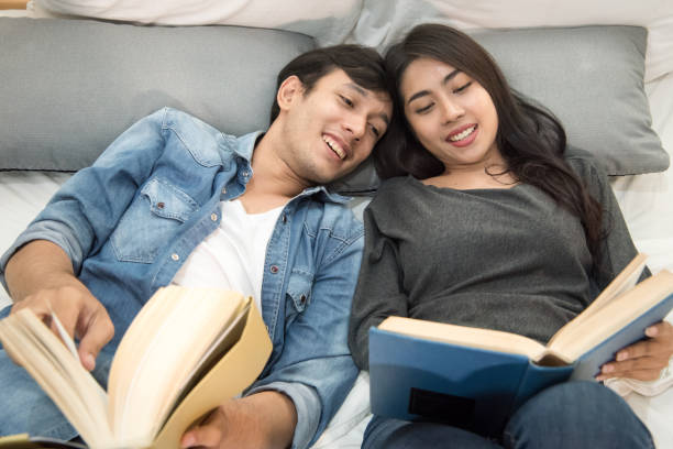 istock Young loving couple reading book at home. 809982484