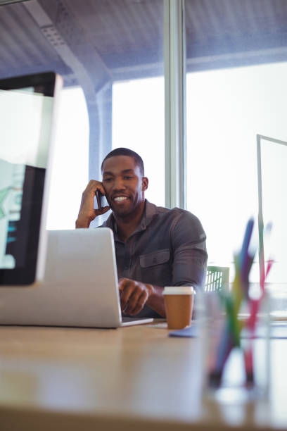 istock Smiling businessman talking on phone in creative office 809982556