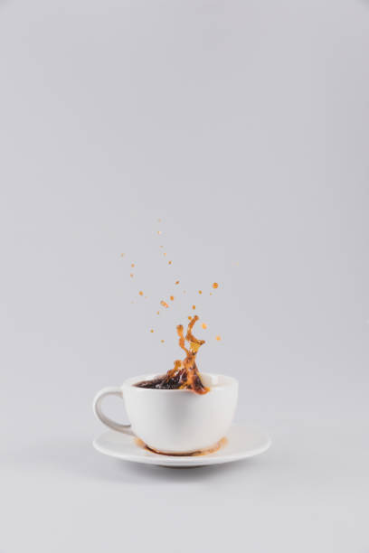 istock coffee splashing out of white cup on saucer, isolated on grey with copy space 809982968