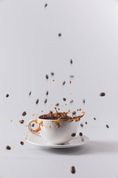 istock white coffee cup with falling coffee grains isolated on grey with copy space 809983110