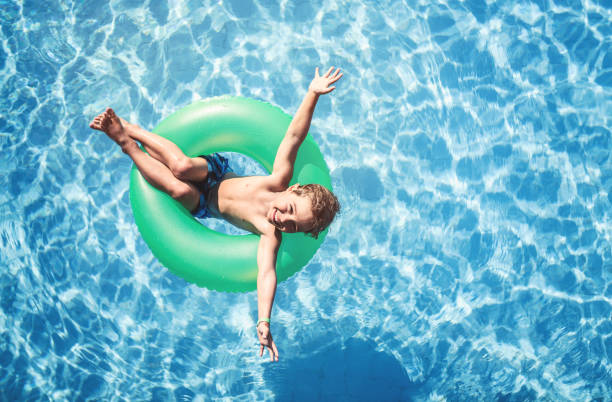 istock Happy boy floating on swim ring in the swimming pool 809983296