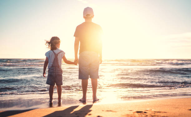 istock Children walking on the beach at sunset 809986208
