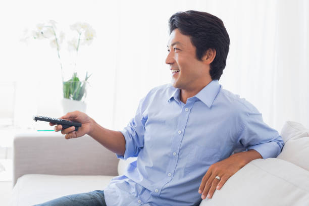 istock Happy man relaxing on couch watching tv 809994742