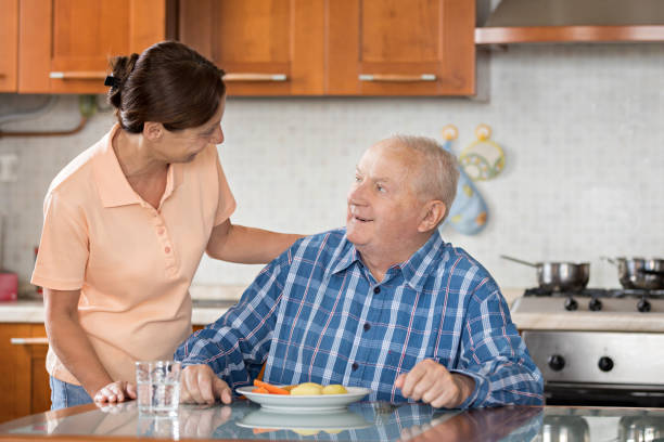 年配の男性ランチを与える介護 - senior adult nursing home eating home interior ストックフォトと画像