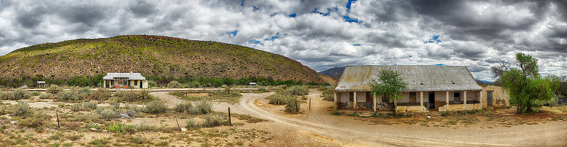 High Dynamic Range Panoramic Image of an abandoned train station with a dramatic cloudy sky and hill behind Vondeling Karoo South Africa