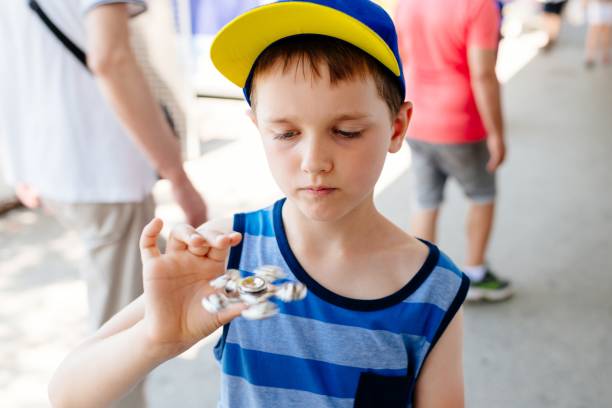 istock Little child boy playing with fidget spinner 810022774