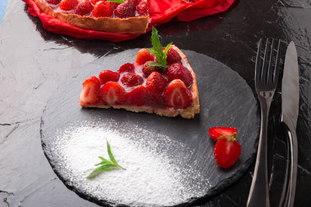 istock Strawberry pie on black slate plate. One piece. Close up. 810028240