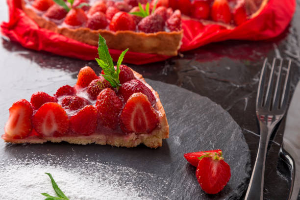 istock Strawberry pie on black slate plate. One piece. Close up. 810028270