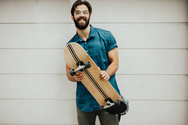 istock Happy bearded man holding skateboard 810031356