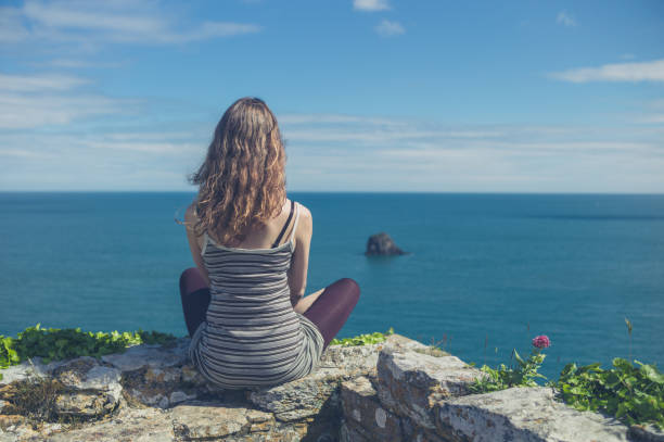 istock Woman relaxing on wall by the sea 810044920