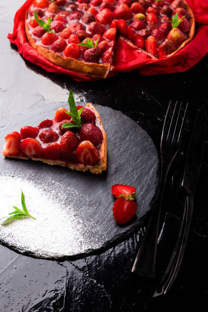 istock Strawberry pie on black slate plate. One piece. Close up. 810057624
