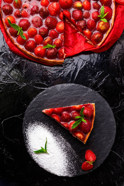 istock Strawberry pie on black slate plate. One piece. Top view. 810057632