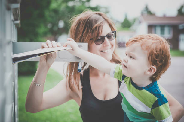 istock Baby Boy Opening a Mailbox with Parent 810064062
