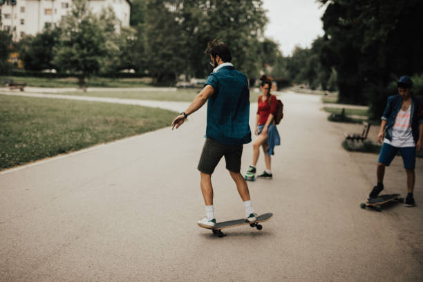 istock Friends at the public park are skateboarding 810066568