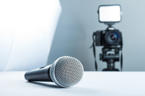 Concept interview, wireless microphone and video camera (DSLR camera) in studio on a white background.