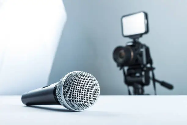 Photo of Concept interview, wireless microphone and video camera (DSLR camera) in studio on a white background.