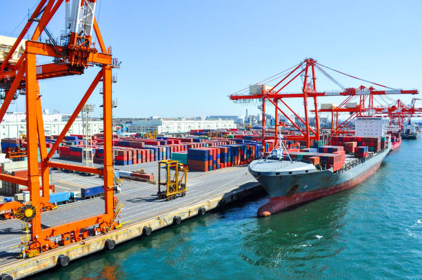 контейнерное судно в порту на контейнерном терминале. корабли контейнеровозов стоят в терминале порта при погрузке, разгрузке контейнера - циндао стоковые фото и изображения