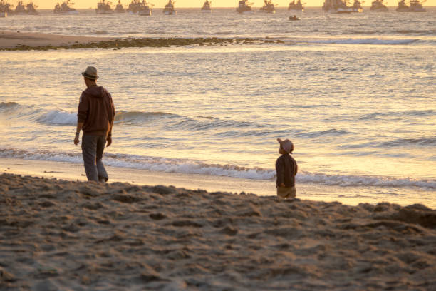 Mancora, Peru - June 2016: Father and son walking at Beautiful sunset in Mancora Beach - Mancora, Peru