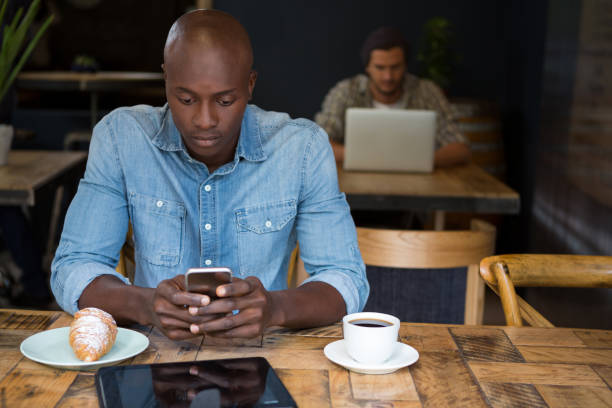 hombre usando el teléfono móvil en madera mesa de café - croissant telephone coffee shop on the phone fotografías e imágenes de stock