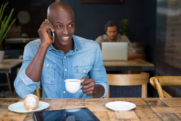 hombre hablando por teléfono mientras café en cafetería - croissant telephone coffee shop on the phone fotografías e imágenes de stock
