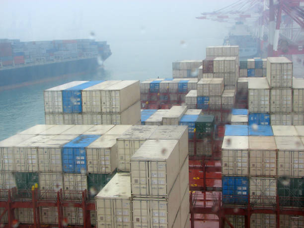 istock Container ship in port at container terminal when there is strong fog and torrential tropical rain. Ships of container ships stand in terminal of port on loading, unloading container 810072066