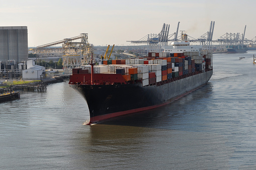 A large merchant ship container vessel in coastal waters of Savannah USA. A merchant ship is moving in daytime